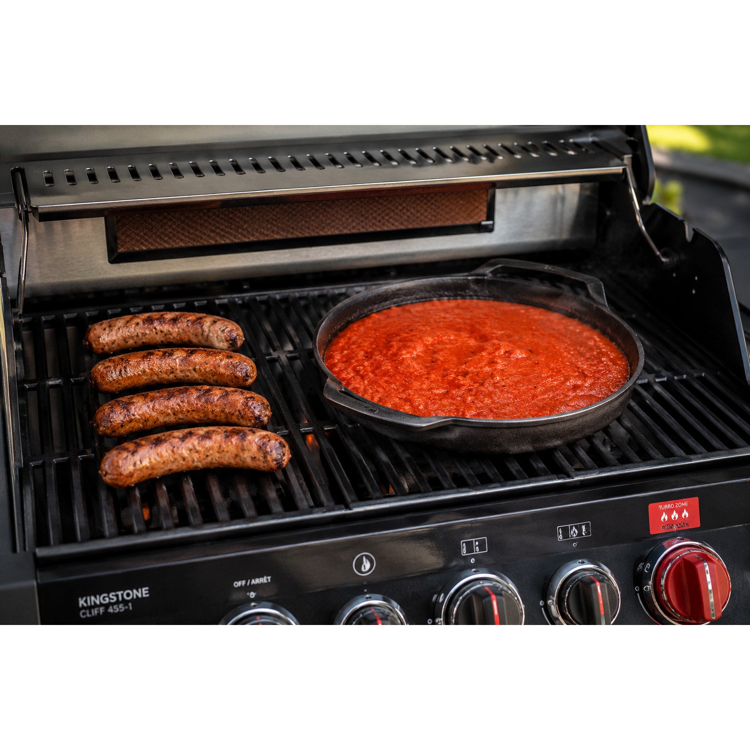 Currysoße im Dutchoven und Currywurst auf einem Gasgrill